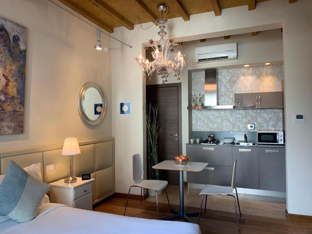 1 dormitorio con cama, mesa y cocina en Florence Art Apartments, en Florencia