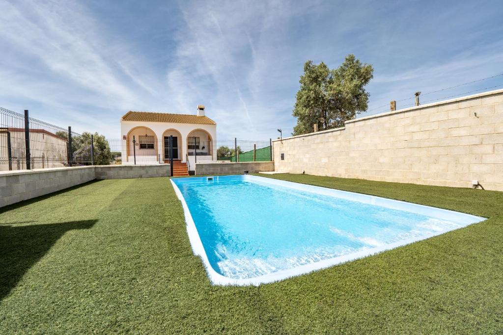 a swimming pool in the yard of a house at Casa rural Montemayor in Moguer