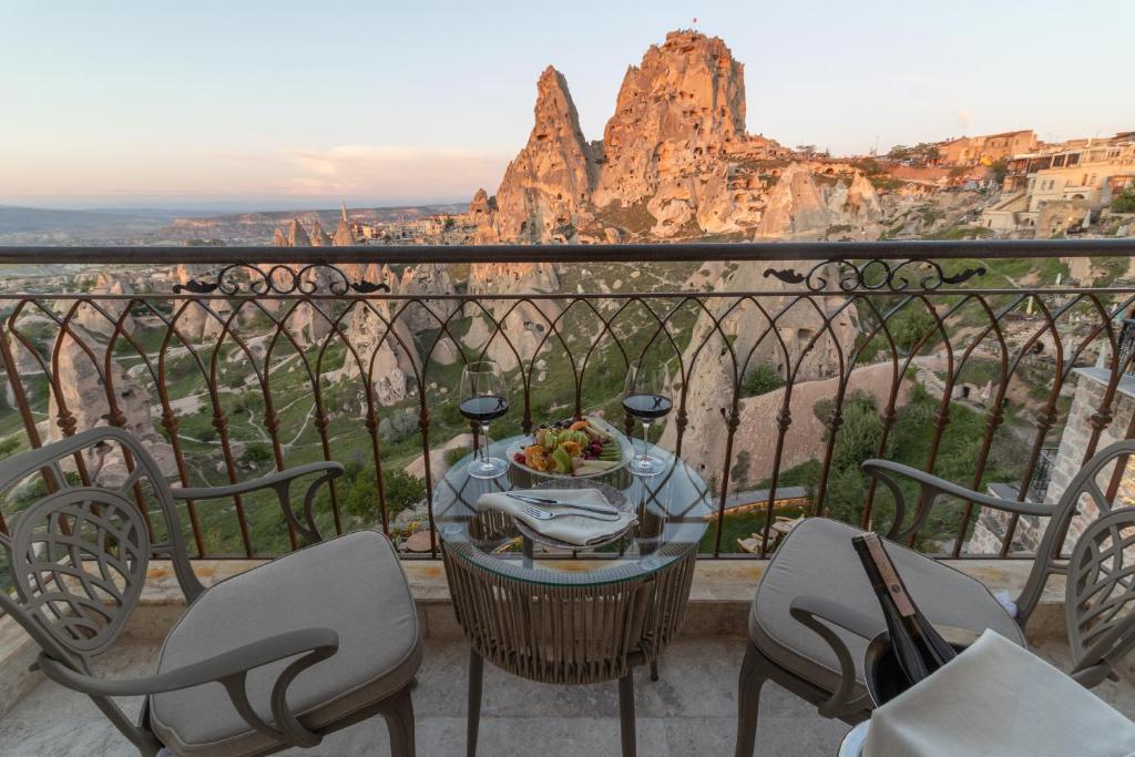 a table and chairs on a balcony with a view of the grand canyon at Via Regia Cappadocia Hotel in Uçhisar