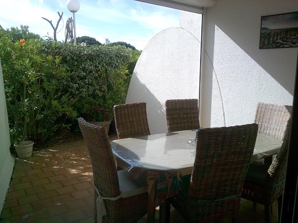 une table et des chaises sur une terrasse avec une fenêtre dans l'établissement Vittoria immobilier-PACIFIC PLAGE - Chèques Vacances acceptés., à La Grande Motte
