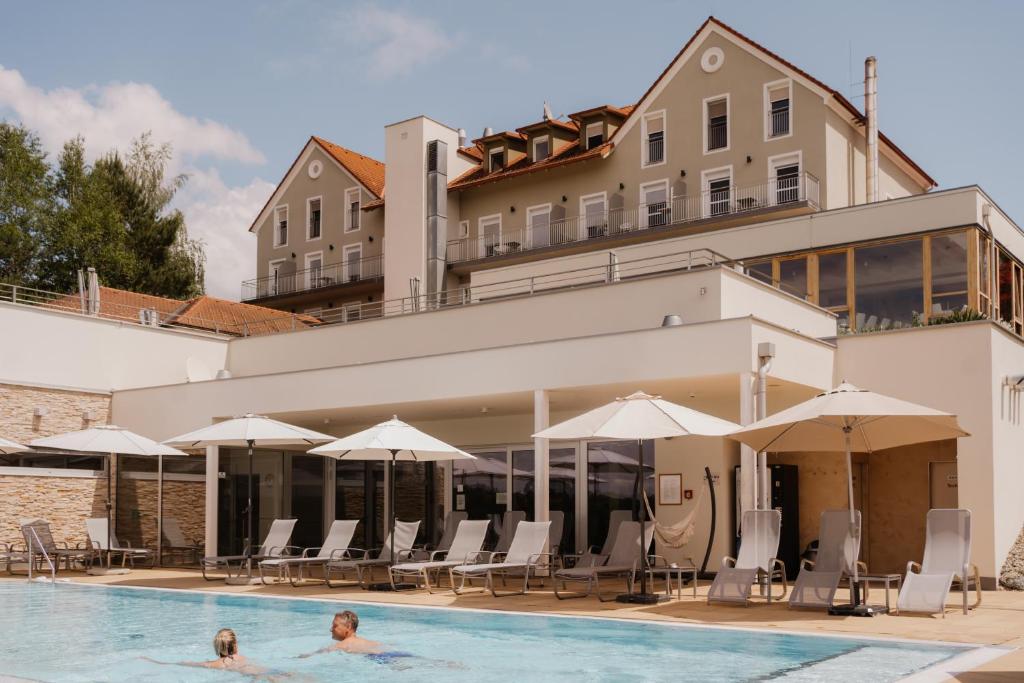 dos personas nadando en una piscina en un hotel en Das Eisenberg, en Sankt Martin an der Raab