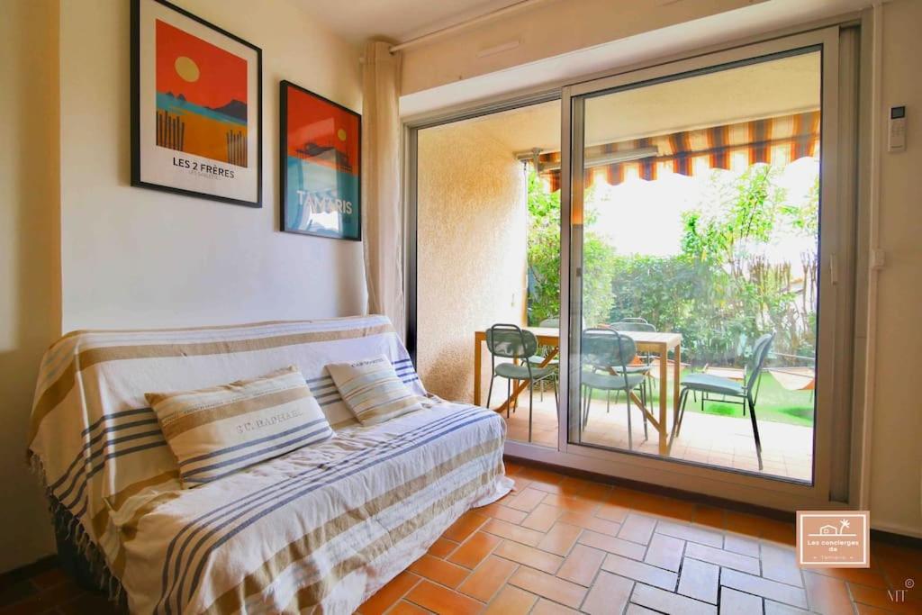 Un dormitorio con una cama y un balcón con una mesa. en L’alyzarine, en La Seyne-sur-Mer
