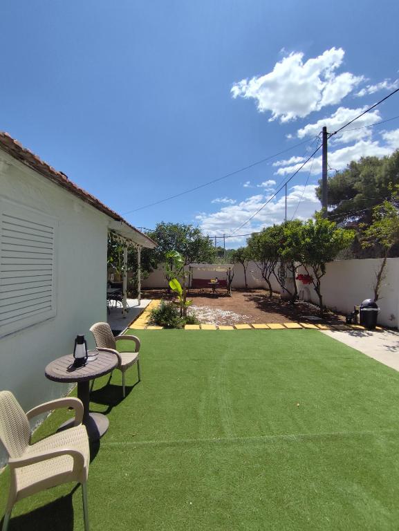 a backyard with chairs and a table and grass at Johnson House in Rafina