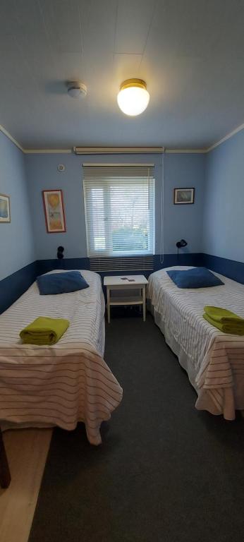Duas camas num quarto com paredes azuis em Eden Billnäs em Billnäs