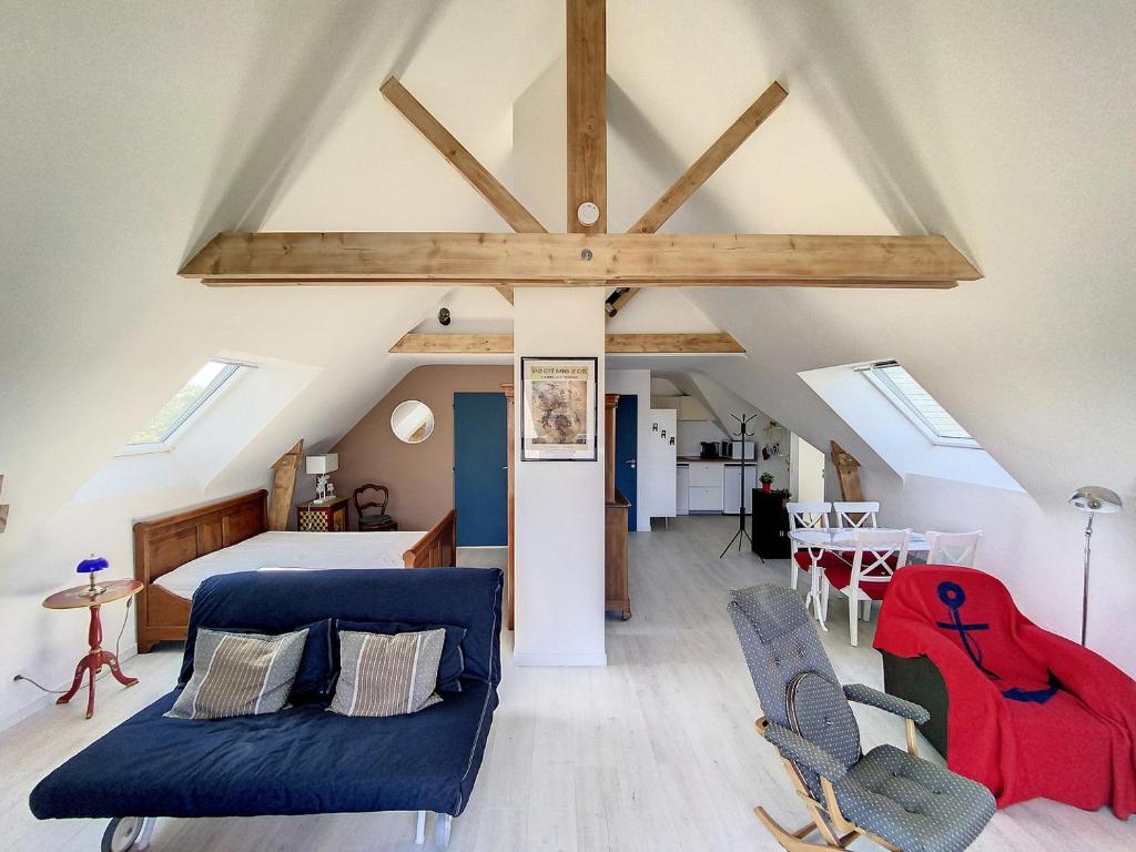 - une chambre mansardée avec un lit et des chaises dans l'établissement Cap Sterenn, à Quiberon
