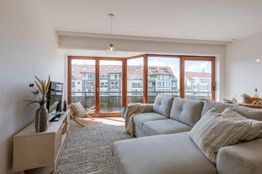 ein Wohnzimmer mit einem Sofa und einem großen Fenster in der Unterkunft Comfortable apartment near the sea in Knokke-Heist