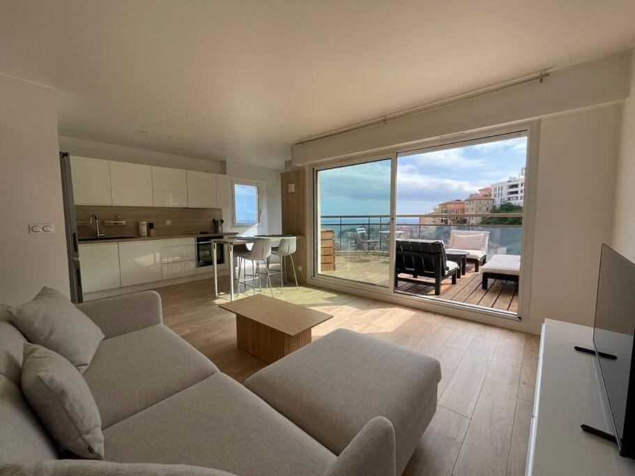 un salon avec un canapé et une grande fenêtre dans l'établissement Bellavista, à Beausoleil