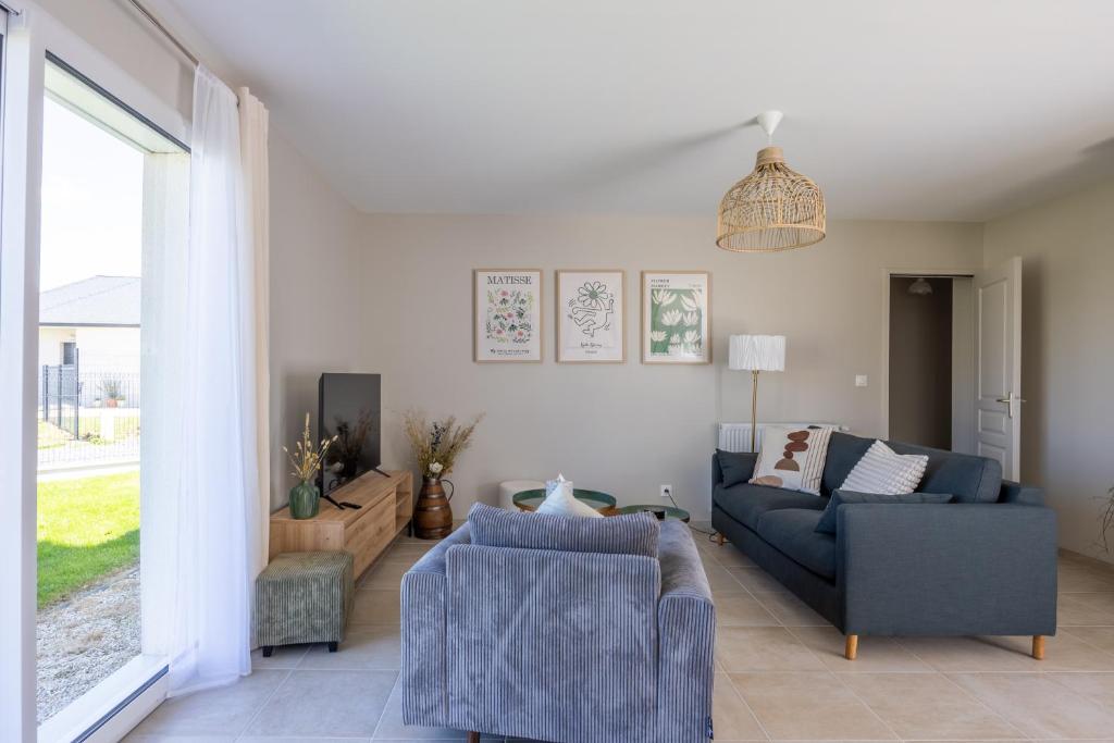 a living room with a couch and a chair at La petite maison de Littry in Le Molay-Littry