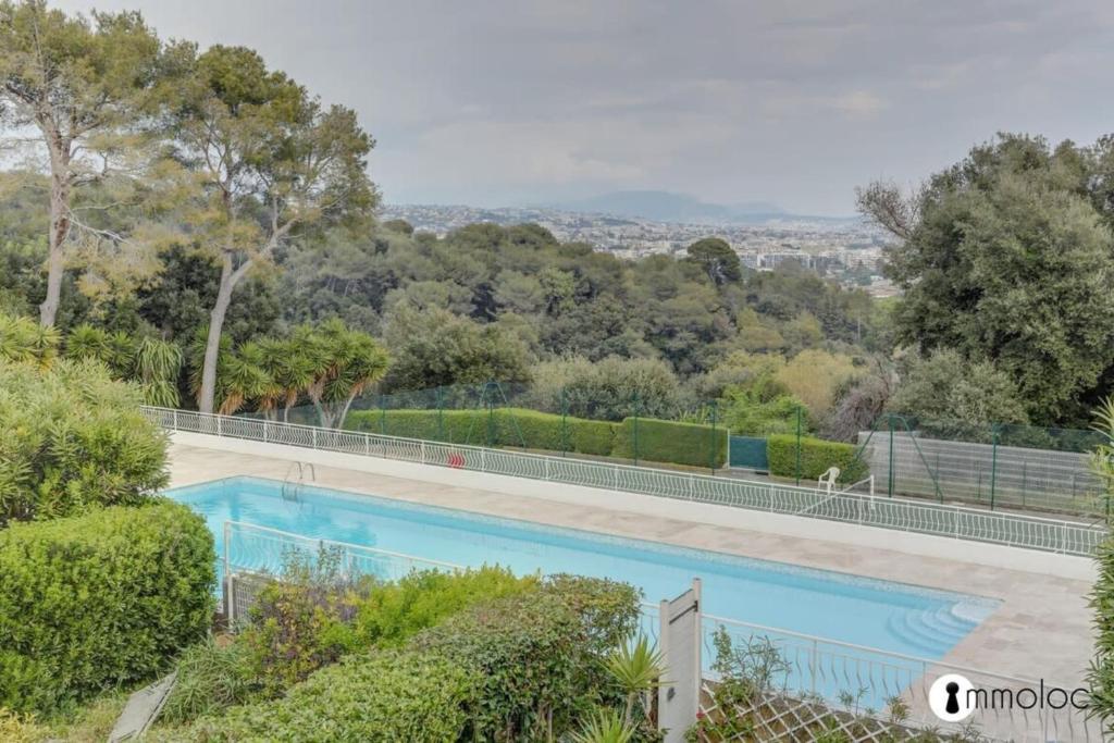 - une piscine dans une cour arborée dans l'établissement Air-conditioned house in residence with swimming pool and tennis court, à Villeneuve-Loubet