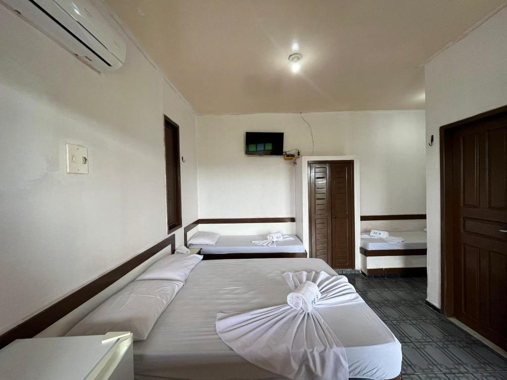 1 dormitorio con 2 camas y TV en la pared en Pargos Club de Salinas en Salinópolis
