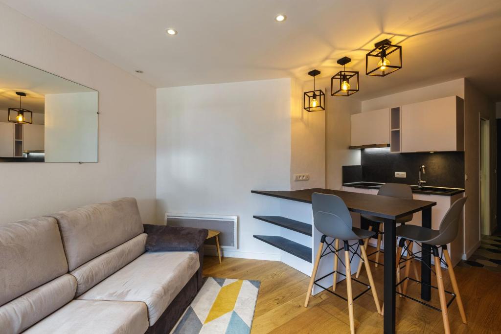 ein Wohnzimmer und eine Küche mit einem Sofa und einem Tisch in der Unterkunft Chamonix Sud - Lognan 106 - Happy Rentals in Chamonix-Mont-Blanc