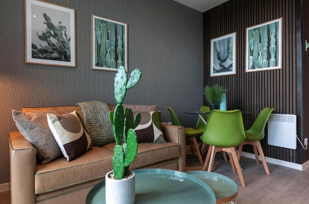 a living room with a couch and a table with a cactus at Palm Tree House - Sahara in Orpington