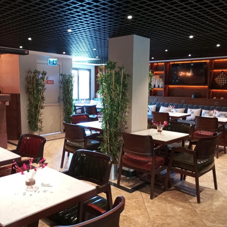 a dining room with tables and chairs and plants at Cihangir Hotel Bosphorus in Istanbul