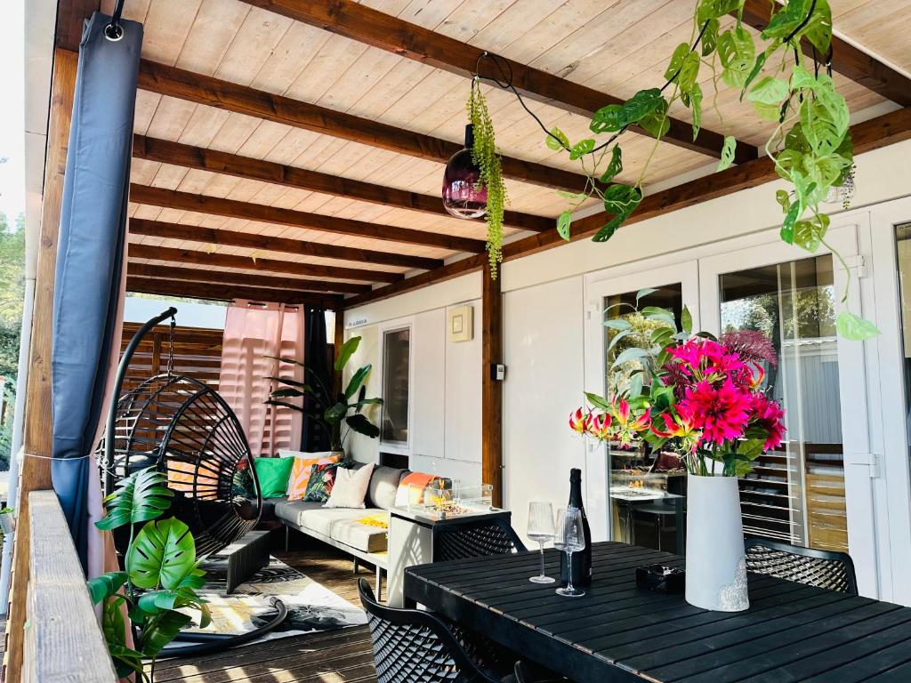 a patio with a table with flowers and a couch at Lucija Mobile Home in Biograd na Moru