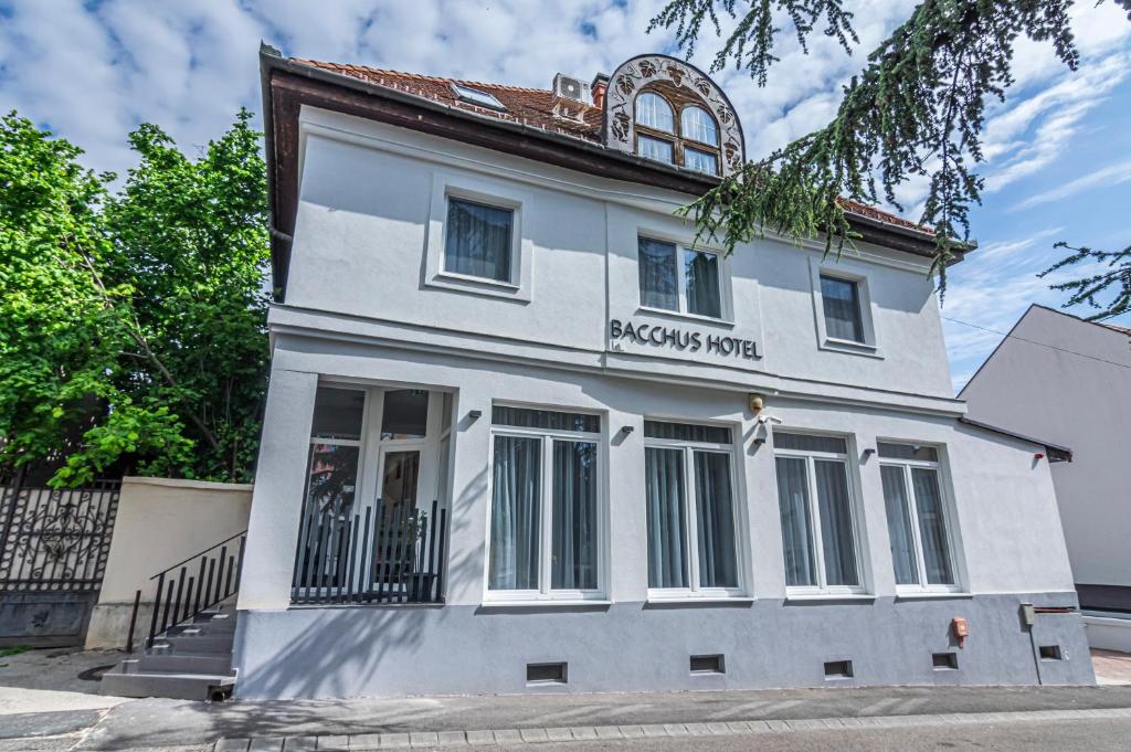 un edificio blanco con un cartel que lee la casa Parsons en Hotel Bacchus en Keszthely