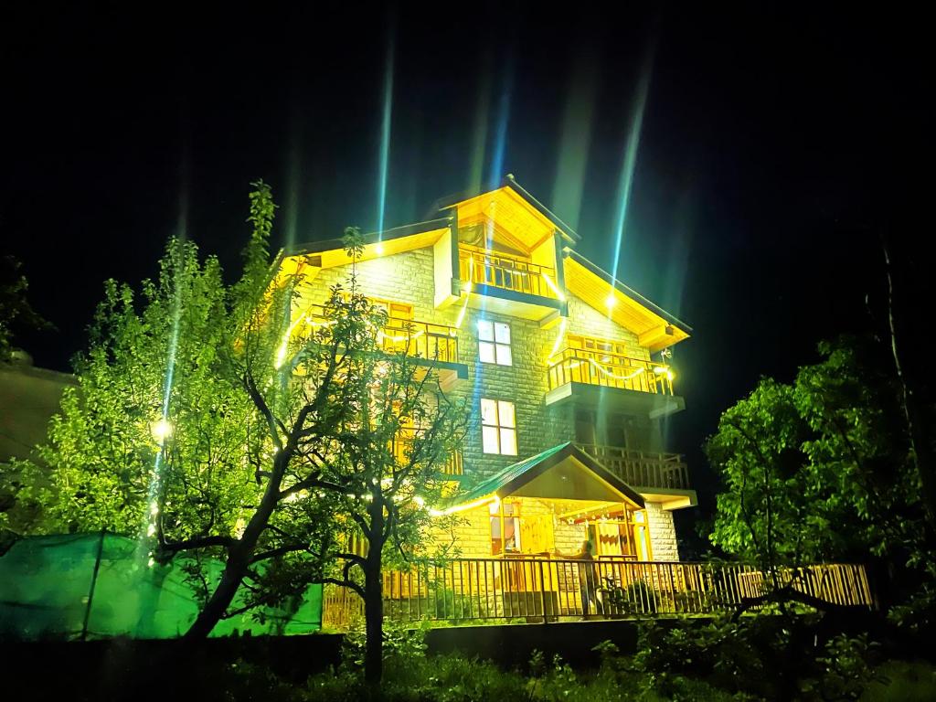 ein großes Haus in der Nacht mit Beleuchtung in der Unterkunft Heavens retreat,Club nirvana stays in Vashisht