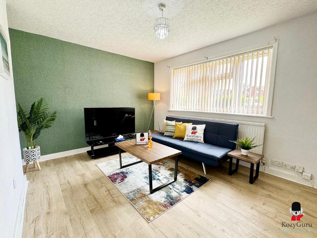 a living room with a blue couch and a table at KozyGuru Spacious 3 BR 8ppl Hse 50% off Long stay in Manchester