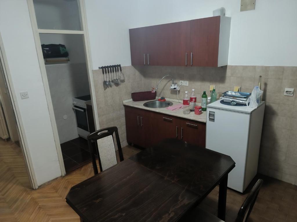 a small kitchen with a sink and a white refrigerator at Stan na dan in Valjevo