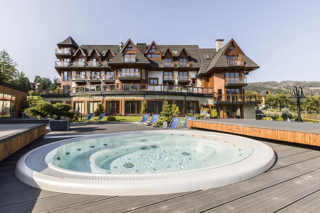 a large house with a hot tub on a deck at Mountain Palace Tatra Resort & SPA in Kościelisko