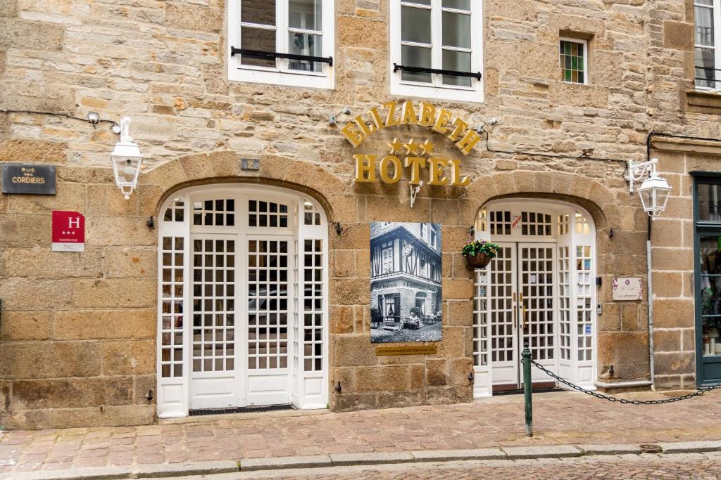 - un hôtel avec des portes blanches dans un bâtiment en pierre dans l'établissement Hotel Elizabeth - Intra Muros, à Saint-Malo