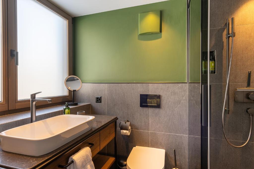 a bathroom with a sink and a shower at Hotel ZERMAMA Zermatt in Zermatt