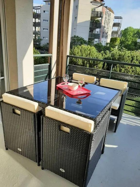 a table with two wine glasses on a balcony at Appartement d'une chambre avec vue sur la ville terrasse amenagee et wifi a Saint Germain en Laye in Saint-Germain-en-Laye