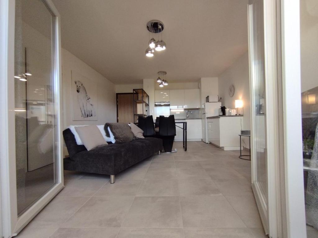 un salon avec un canapé et une cuisine dans l'établissement ALBI ville T2 Confortable et moderne, à Albi