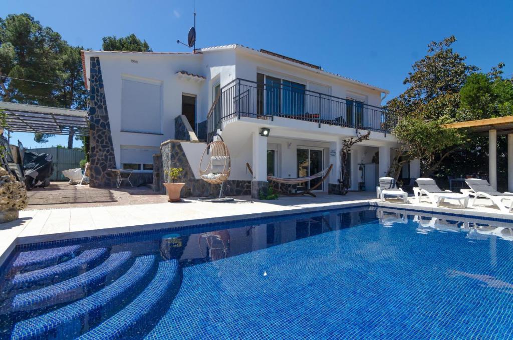 uma villa com piscina em frente a uma casa em Club Villamar - Hestia em Lloret de Mar