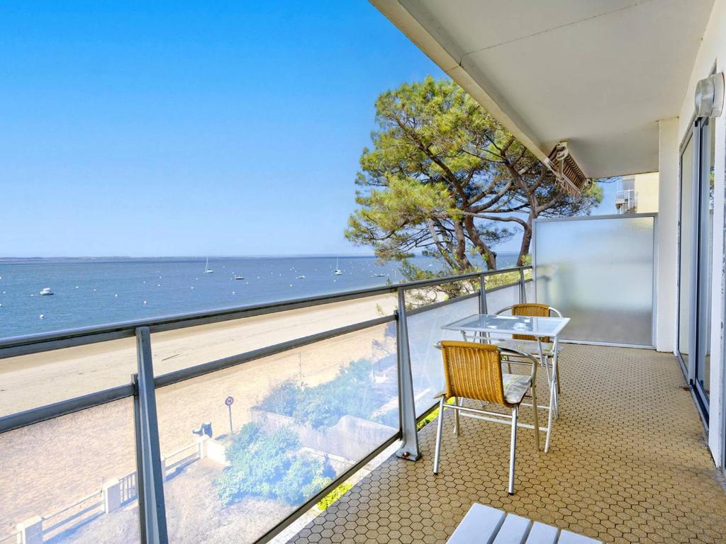un balcon avec une table et des chaises et l'océan dans l'établissement Arcachon Pereire - T2 Front de Mer avec Balcon et Parking - FR-1-433-26, à Arcachon