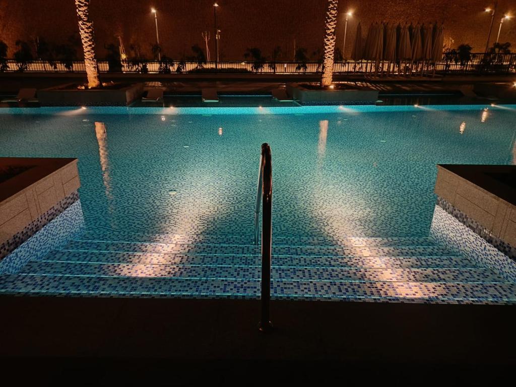 an empty swimming pool at night with lights at cozy house in Cairo