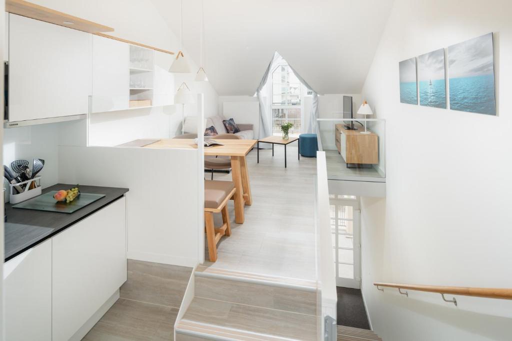 a kitchen and dining room with white cabinets and a dining table at Nordstrandperle Ap O8 in Norderney