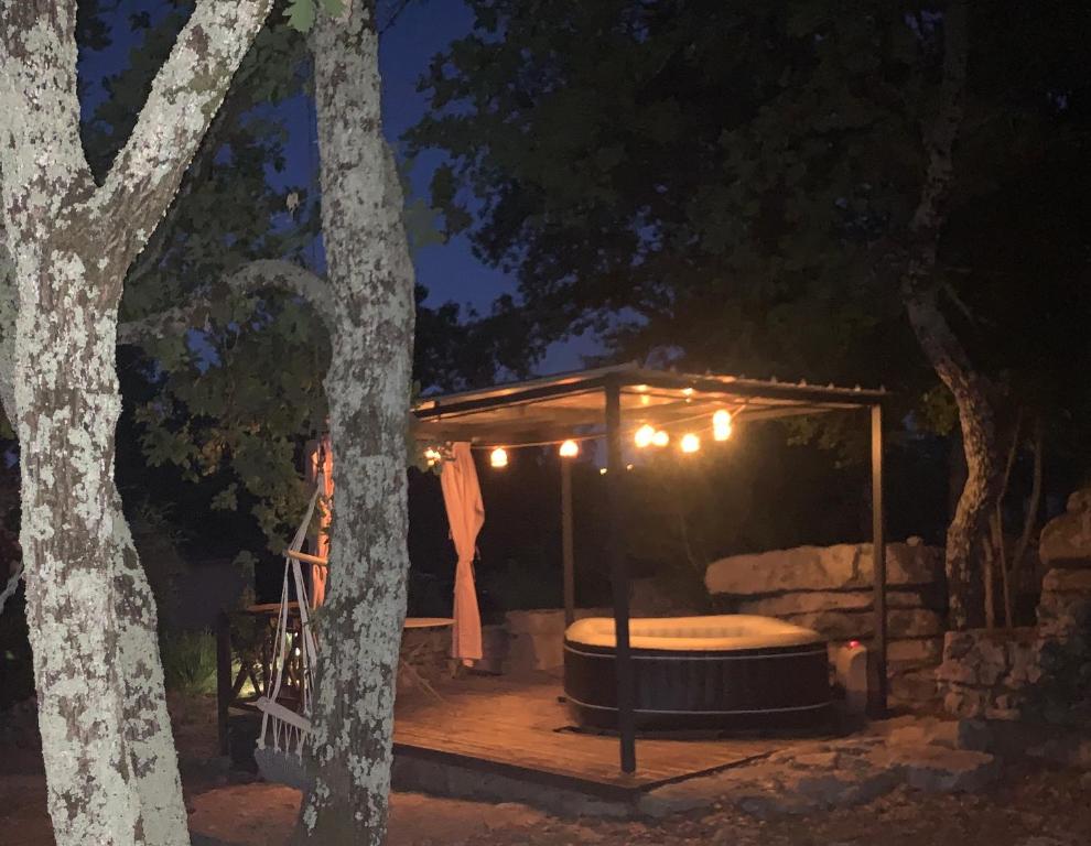 a gazebo with a hot tub at night at Le Mazet, studio avec terrasse et spa in Saint Alban Auriolles