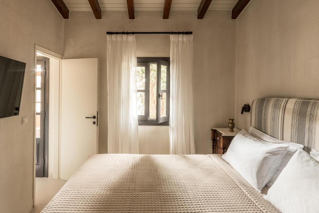 a bedroom with a bed and a window at Koutouloufari Village Holiday Club in Hersonissos