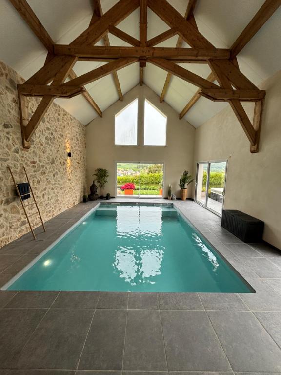 a swimming pool in a house with a vaulted ceiling at Les deux piliers in Courthiézy