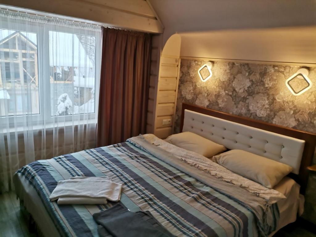 Cama en habitación con ventana y cama sidx sidx sidx sidx en Zaviy, en Yaremche