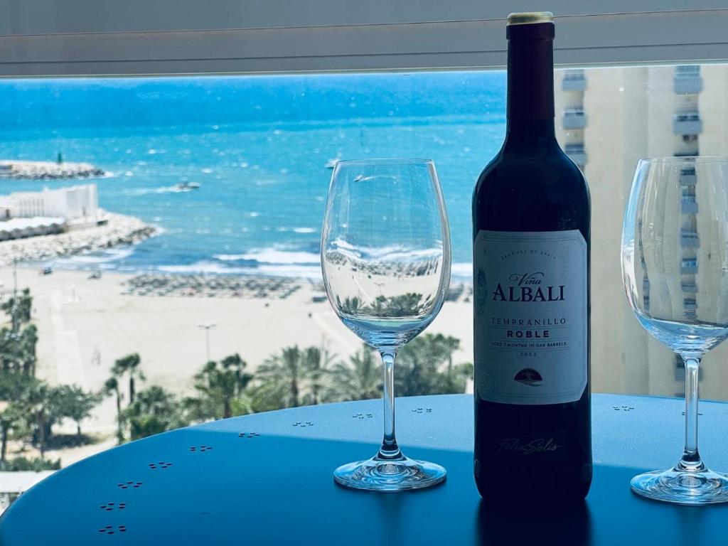 una bottiglia di vino seduta accanto a due bicchieri di vino di The eighth wonder! Views and location a Benalmádena