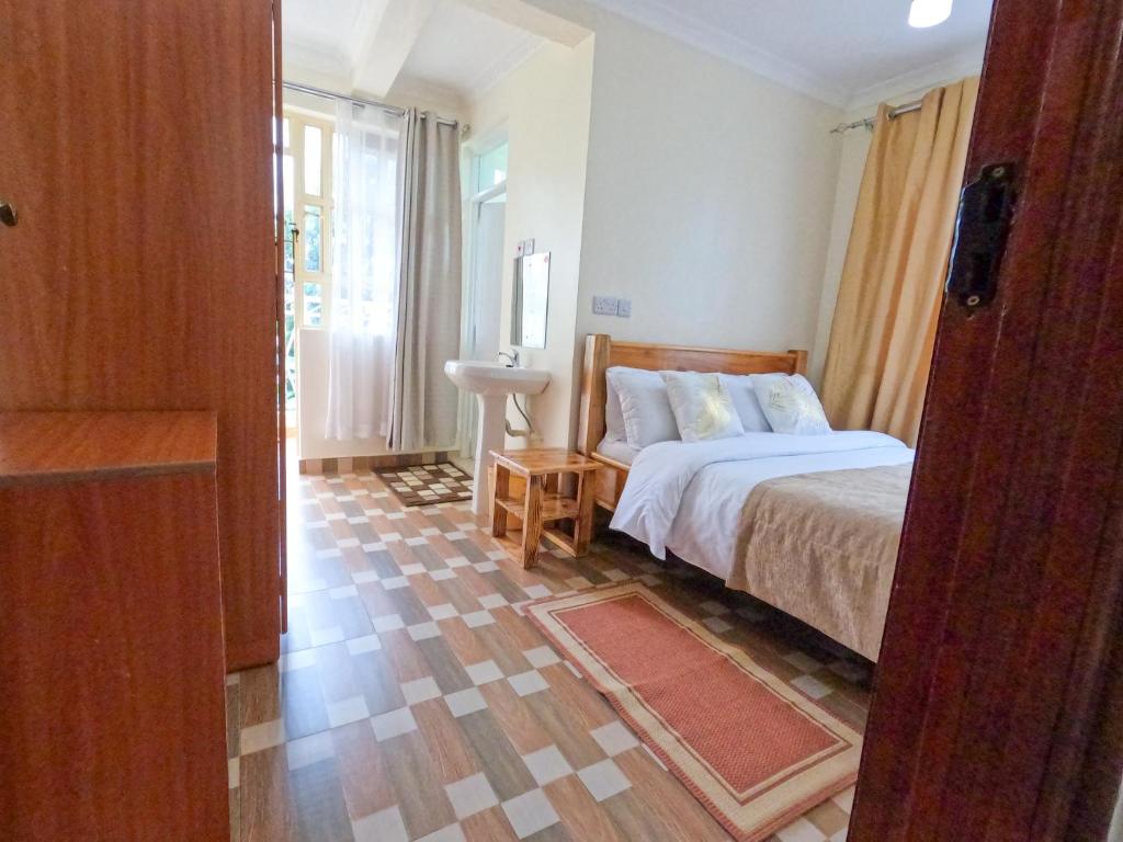 a bedroom with a bed and a sink in it at Mayas Suites in Nyeri