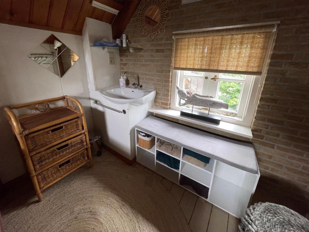 una pequeña cocina con fregadero y ventana en Galerie Petit Delfshaven, en Róterdam
