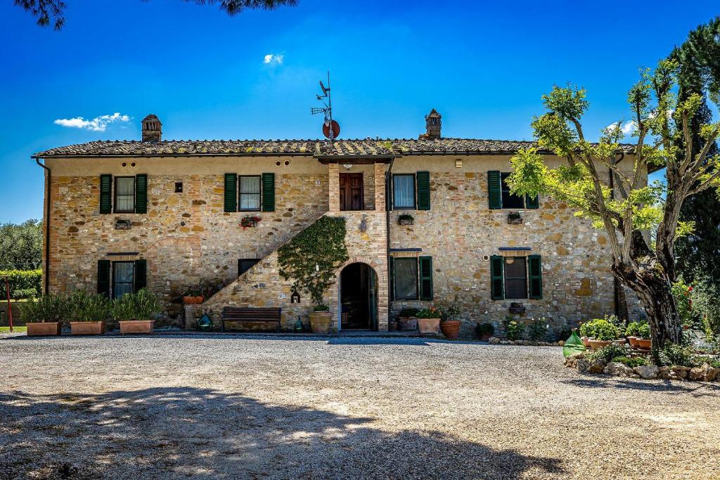uma grande casa de pedra com uma grande entrada em La Fornace Di Racciano em San Gimignano