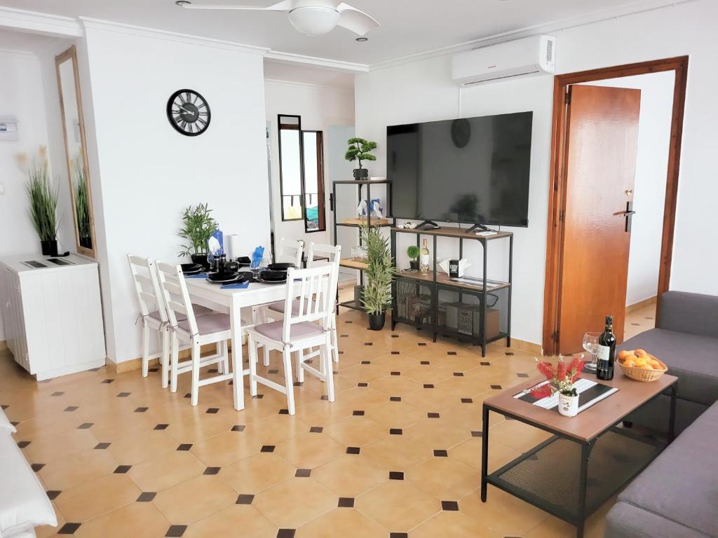 - un salon avec une table et une télévision dans l'établissement Apartamento Veracruz 200 m de la Playa, à Gandía