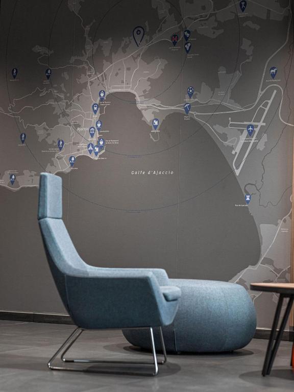 a blue chair in front of a wall with a map at Holiday Inn Express Ajaccio by IHG in Ajaccio