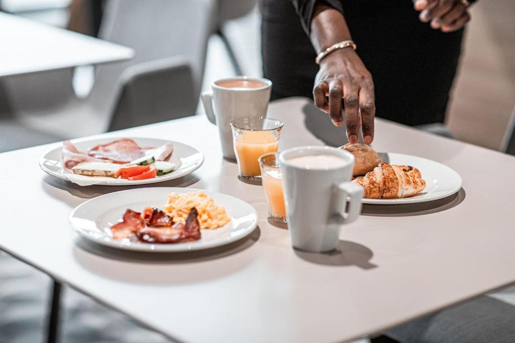 a table with two plates of breakfast food on it at Holiday Inn Express Ajaccio by IHG in Ajaccio