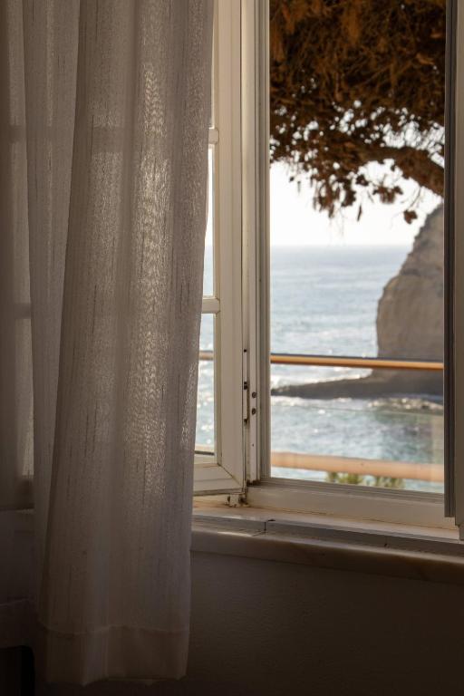 an open window with a view of the ocean at Casa Amarela by Urban Beach Rentals in Carvoeiro
