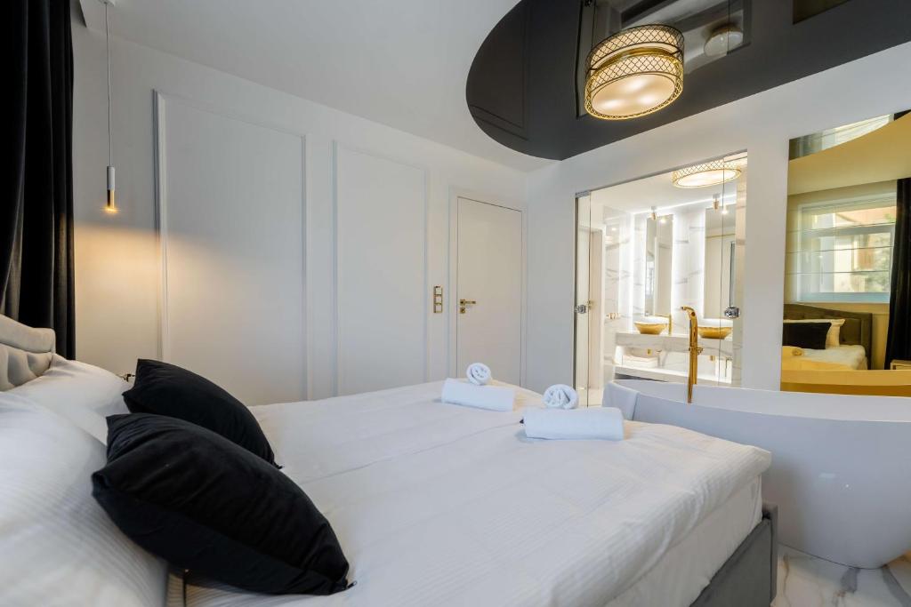 una camera da letto con un grande letto bianco con cuscini neri di Luksusowy Apartament - Plażowa Residence Dream Apart a Szczyrk