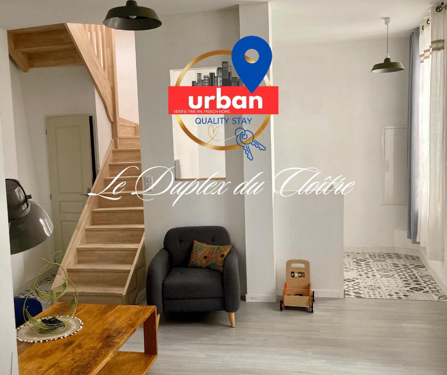 uma sala de estar com um sinal para uma loja de ufootballquality e uma cadeira em Duplex du Cloître 75m2 em Moissac