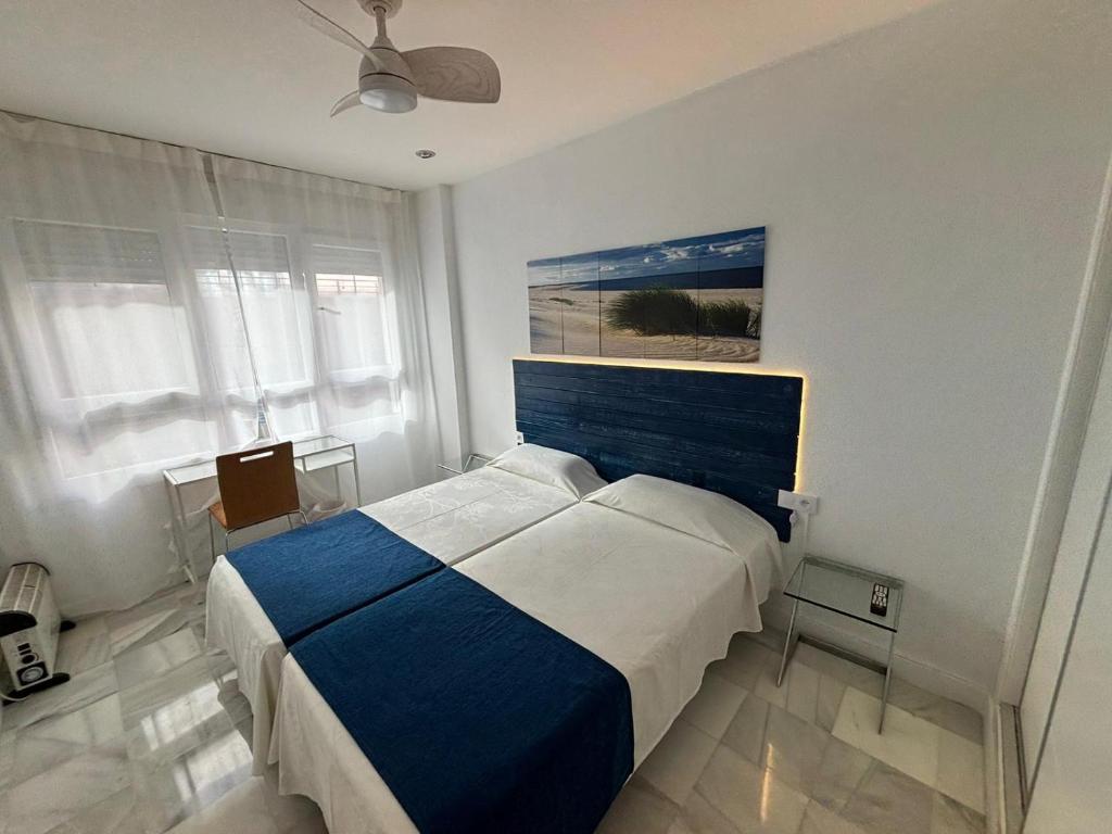 sypialnia z łóżkiem i obrazem na ścianie w obiekcie Apartamentos Turisticos Imar w Kadyksie