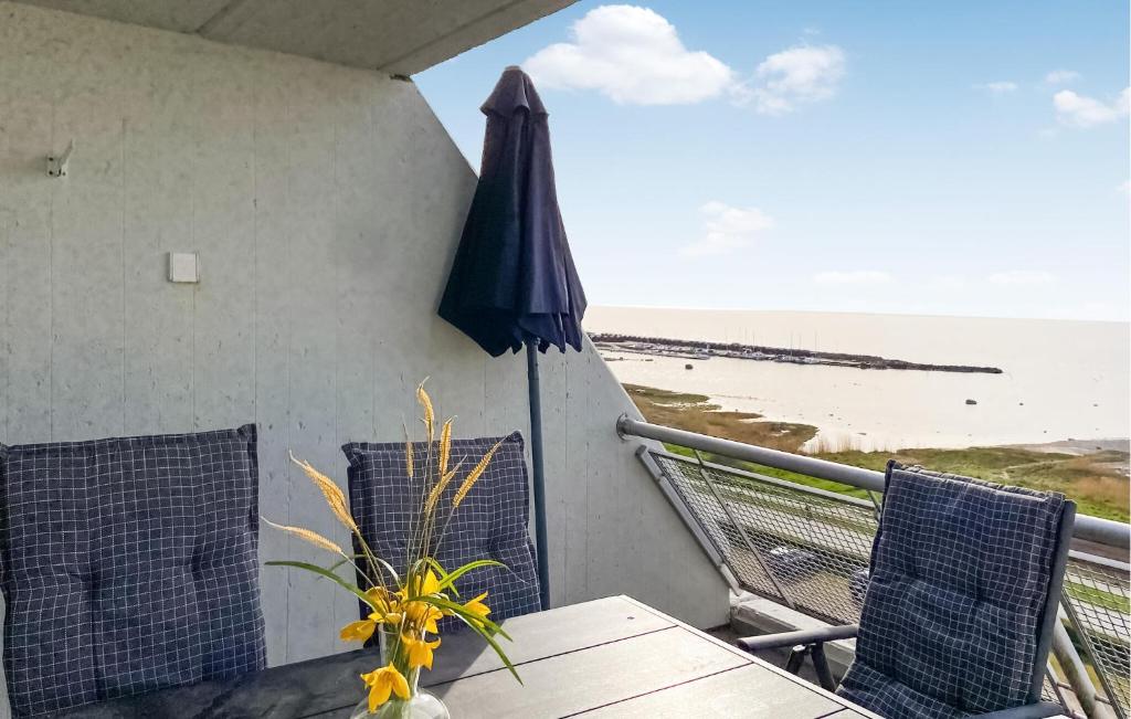 Nice Apartment In Visby With Wifi في فيسبي: فناء مع طاولة ومظلة والشاطئ