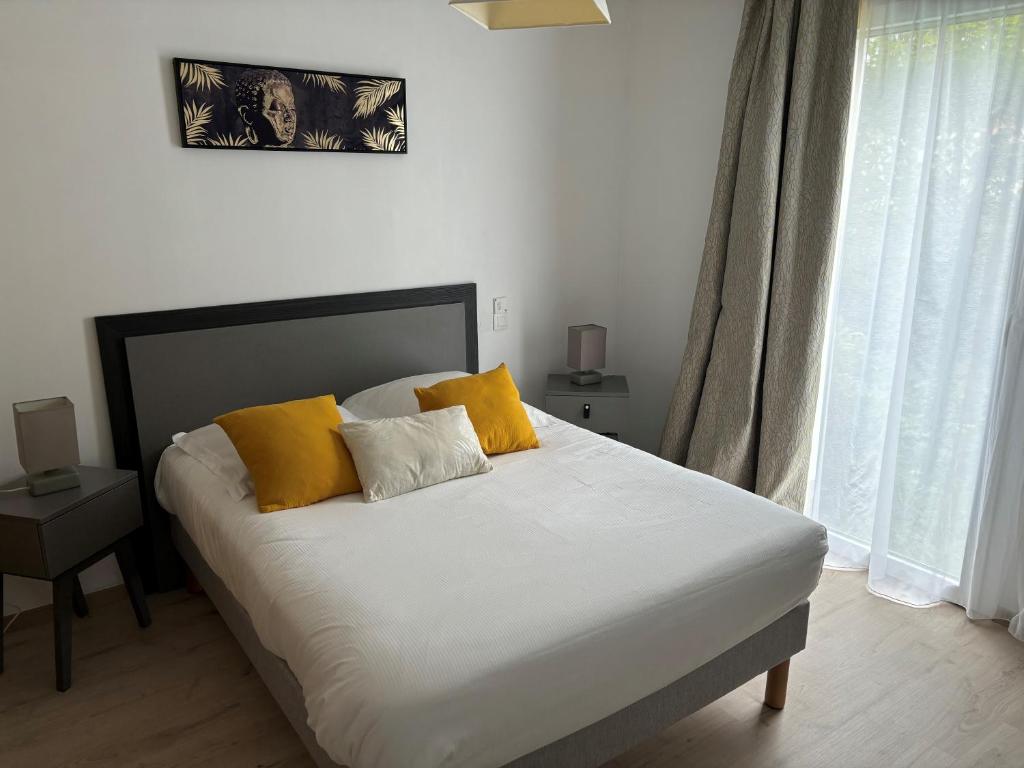 a bedroom with a large bed with yellow pillows at DOMITYS Le Parc de Saint-Cloud in Cambrai