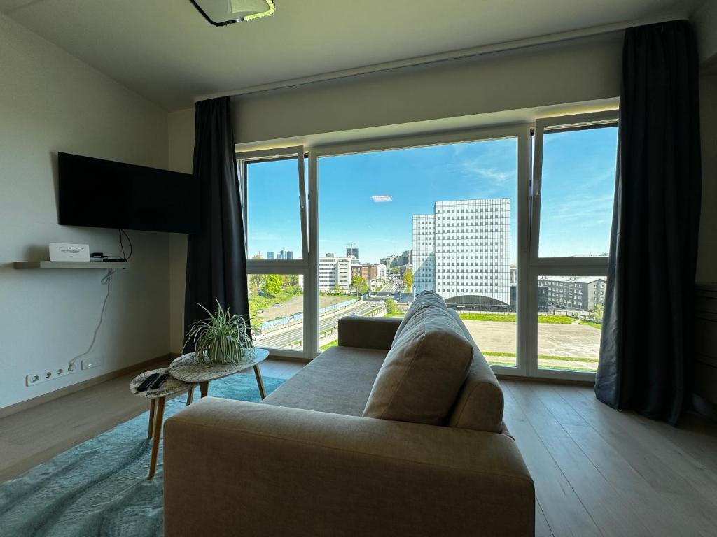 a living room with a couch and a large window at Modern Lux Apartment with Great View in Tallinn