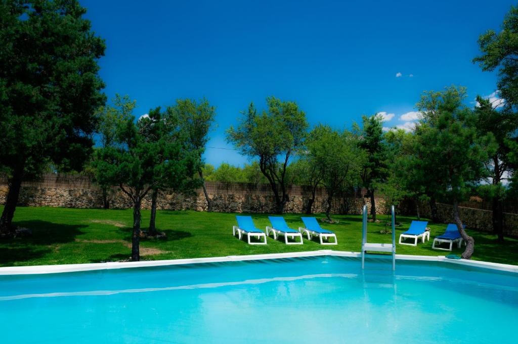 une piscine avec des chaises longues et une fontaine dans l'établissement Los Lebreles Namaste I y II, desconecta en las Hoces del Duratón, à Hinojosas del Cerro